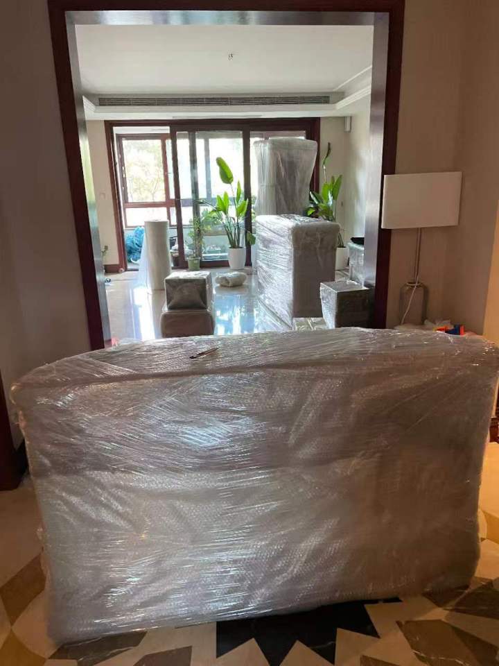 专业打包人员正在对精密物品进行多重防护